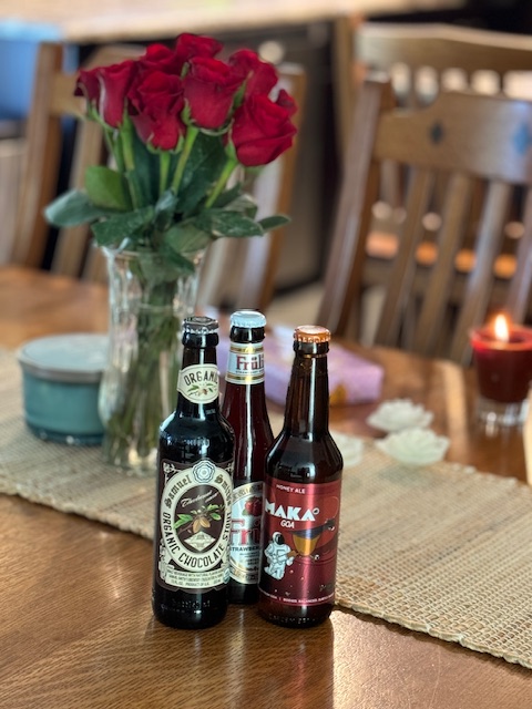 Roses_on_a_table_with_beer_bottles_displayed_candles_and_chocolates
