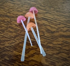 Four silicone pink mushroom bookmarks arranged on a table.