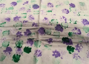 Burp cloth with messy painted stamp marks of blurry flower petals and leaves