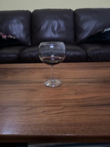 Glass of sherry on a coffee table with a leather sofa in the background.