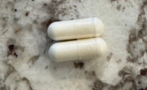 This photo shows two magnesium gel caps placed on a marble countertop.