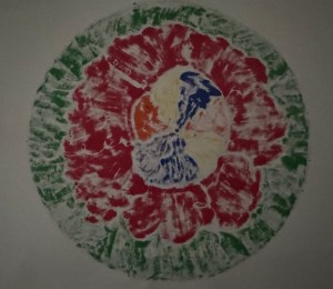 This image shows the reverse side of the mandala from the feature photo for this post. The reverse side is more subtle in color and somewhat faded. It is set against a white background.